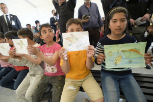 16 avril 2016 : Enfants réfugiés montrant des dessins lors de la visite du pape François, dans le camp de Moria à Lesbos (Grèce).